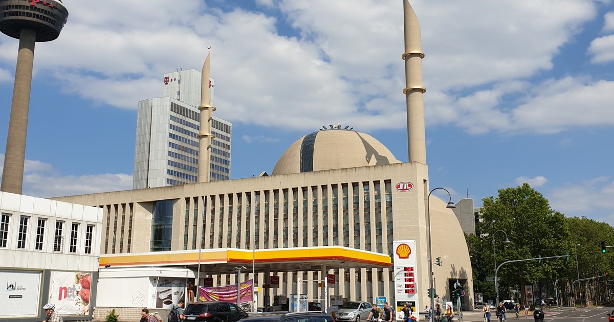 DITIB-Zentralmoschee in Köln-Ehrenfeld von der Venloer Straße aus gesehen, mit Kuppel, zwei Minaretten und Verwaltungsbau, links der Kölner Fernsehturm.