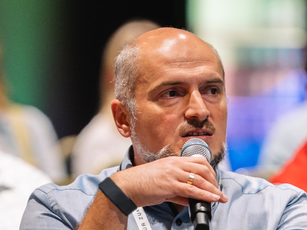 Engin Karahan spricht mit Mikrofon beim Forum IM/PULS in Berlin