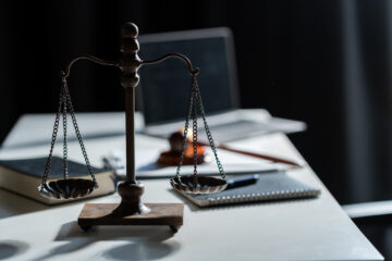 Eine klassische Waage auf einem Tisch, dramatisch beleuchtet, als Symbol für Abwägung und scheinbare Symmetrie.